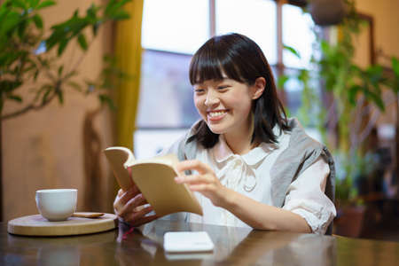 A young woman reading a book in a warm atmosphereの写真素材