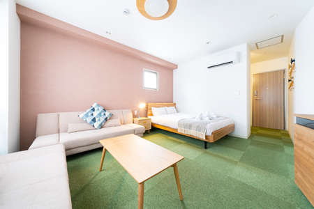 Hotel room with sofa, cushions, table and bed