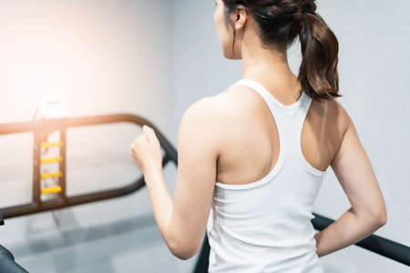 Asian young woman exercising on a treadmill