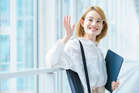 Portrait of a middle-aged woman standing by a bright windowの写真素材