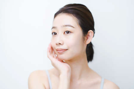 Asian young woman checking the condition of her skinの写真素材