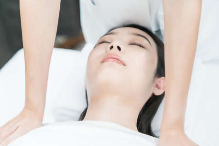 Asian young woman receiving a massage at an esthetic salonの写真素材
