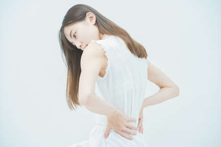 Asian young woman suffering from back painの写真素材