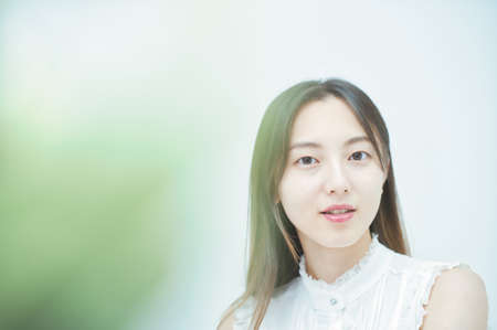 Young woman with a relaxed smile in greenly spaceの写真素材