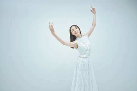 Asian young woman dancing gracefully and white backgroundの写真素材
