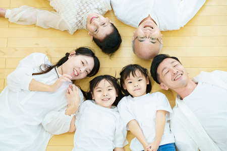 3 generation family lying on the floor in the roomの写真素材
