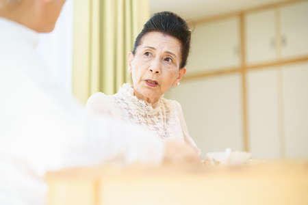 Senior couple chatting in a bright living roomの写真素材
