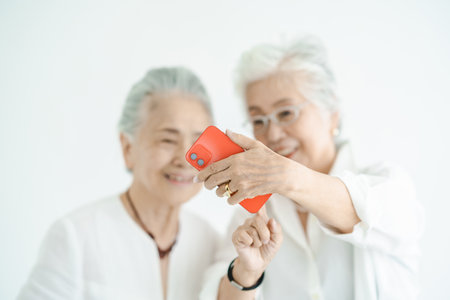 Senior women looking at smartphone screens with a smileの写真素材