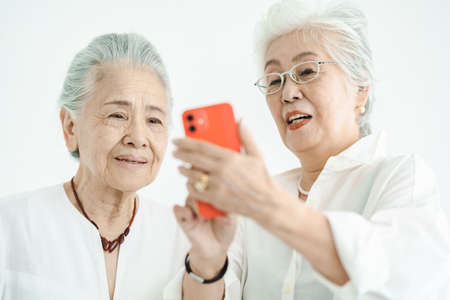 Senior women operating smartphone through trial and errorの写真素材