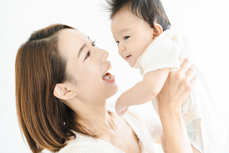 Asian mom holding a baby in the bright roomの写真素材