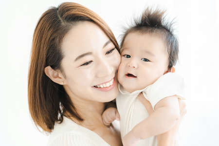 Asian mom holding a baby in the bright roomの写真素材