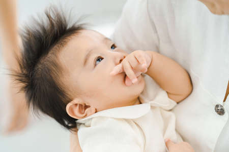 Asian baby to be hugged in a bright roomの写真素材