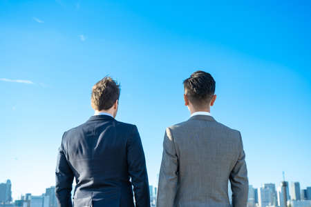 Two business men stands on fine dayの写真素材