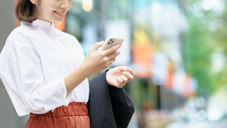 Anonymous woman holding a smartphone outdoorsの写真素材