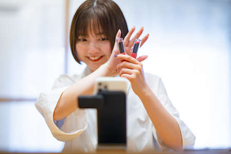 Young woman who introduces cosmetics using a smartphoneの写真素材