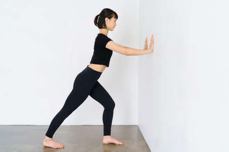 Asian woman doing gymnastics using the wall
