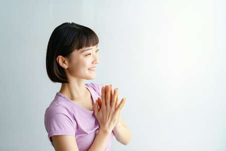 A woman doing yoga poses with her palms together