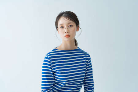 Asian young woman wearing glasses indoorsの写真素材