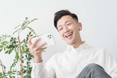 A man looking at a smartphone screen indoors