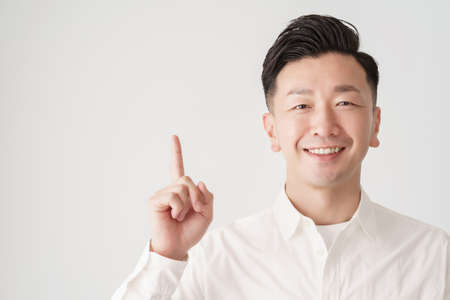 A man posing with his index finger up and white background