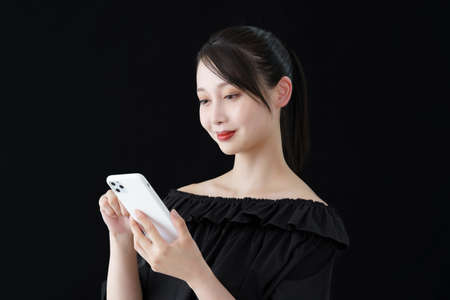 A woman operating a smartphone and black background