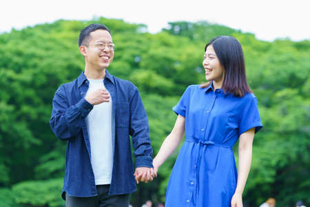 A young couple taking a walk with a smile in the fresh green