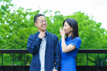 A young couple chatting in a fresh green parkの写真素材