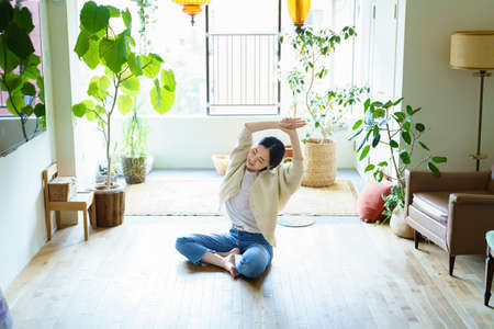 Asian woman stretching in the roomの写真素材