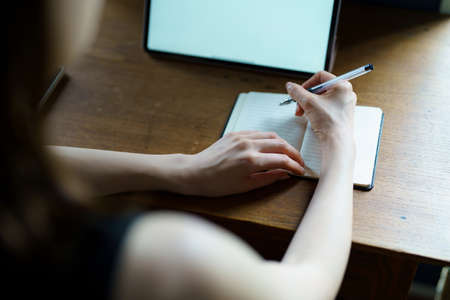 A woman who communicates online using a tablet PC in the room