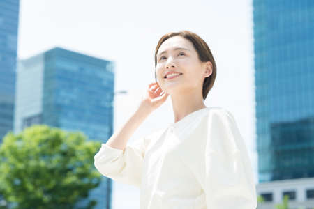 A smiling young woman standing in the office districtの写真素材