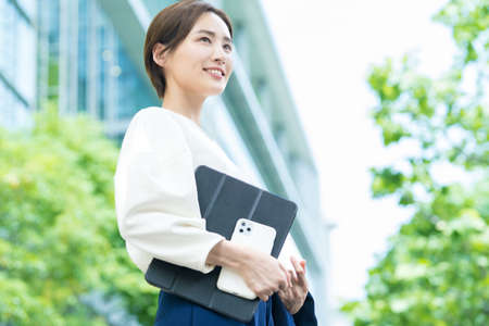 Young woman looking up at the sky (business woman)の写真素材
