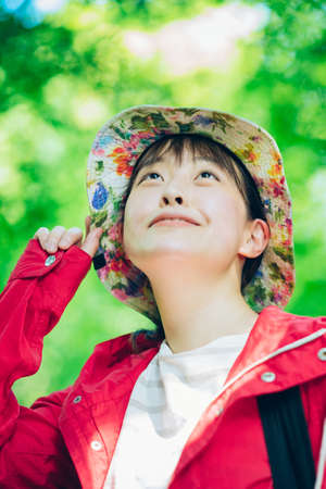 Young woman walking in the fresh green mountainの写真素材