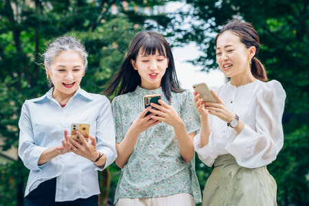asian women of various ages using smartphonesの写真素材