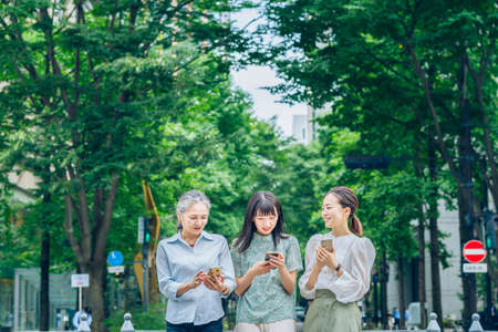 asian women of various ages using smartphonesの写真素材
