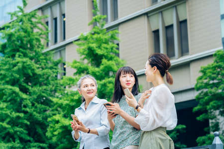 asian women of various ages using smartphonesの写真素材