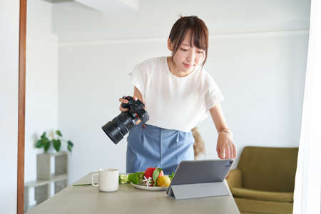 Female photographer checking the photos he took on a monitorの写真素材