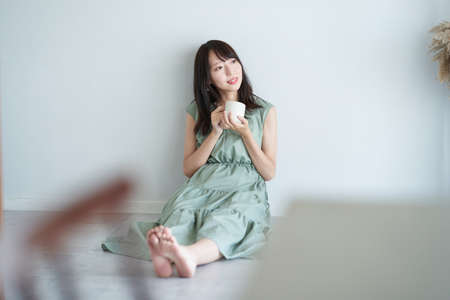 Asian woman relaxing in a simple spaceの写真素材