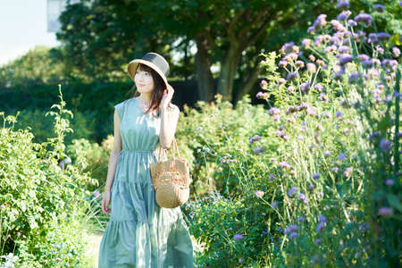 young woman walking in green on fine dayの写真素材