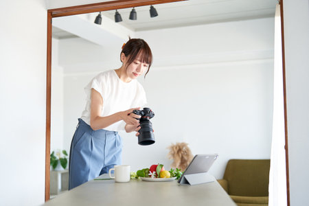 Female photographer checking the photos he took on a monitorの写真素材