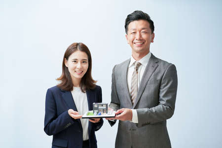 Man and woman in suits with elaborate house modelの写真素材