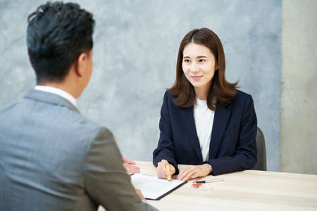 A woman pushing a stamp as a signature on a document in the officeの写真素材