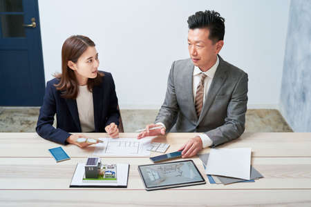 Businessman and businesswoman planning a house designの写真素材
