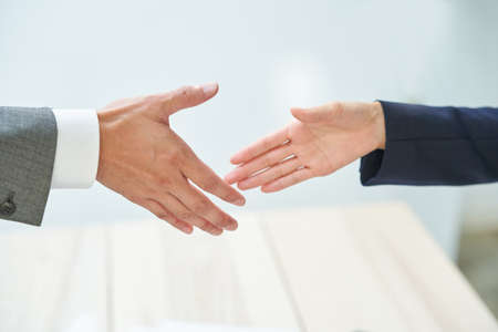 business man and woman shaking hands at office