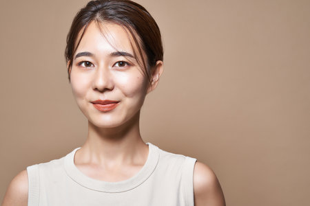 Healthy young woman and beige color backgroundの写真素材