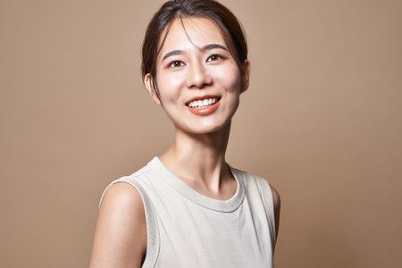 Healthy young woman and beige color backgroundの写真素材
