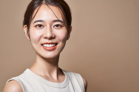 Healthy young woman and beige color backgroundの写真素材