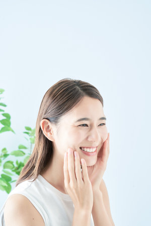 Young woman checking her skin condition in the roomの写真素材