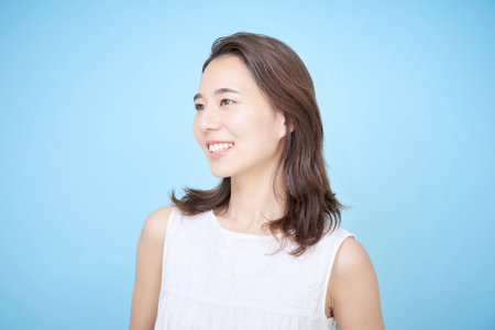 portrait of young woman with blue backの写真素材