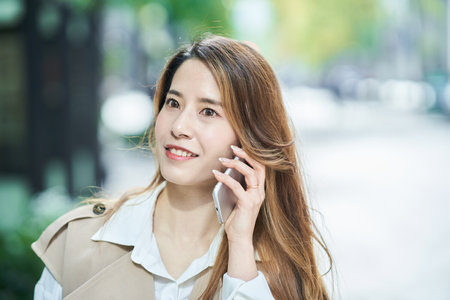Young woman talking on smartphone outdoorsの写真素材