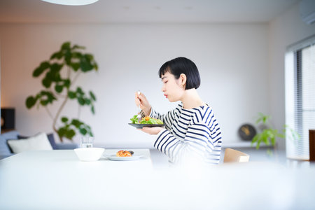 young woman eating at home diningの写真素材